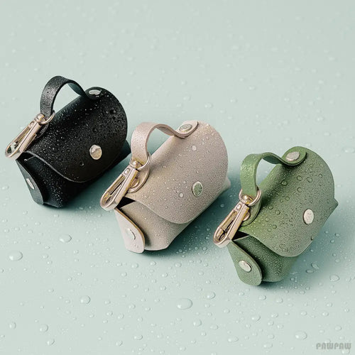 Three small handbags in black, beige, and green on a textured light blue background with rain drops.