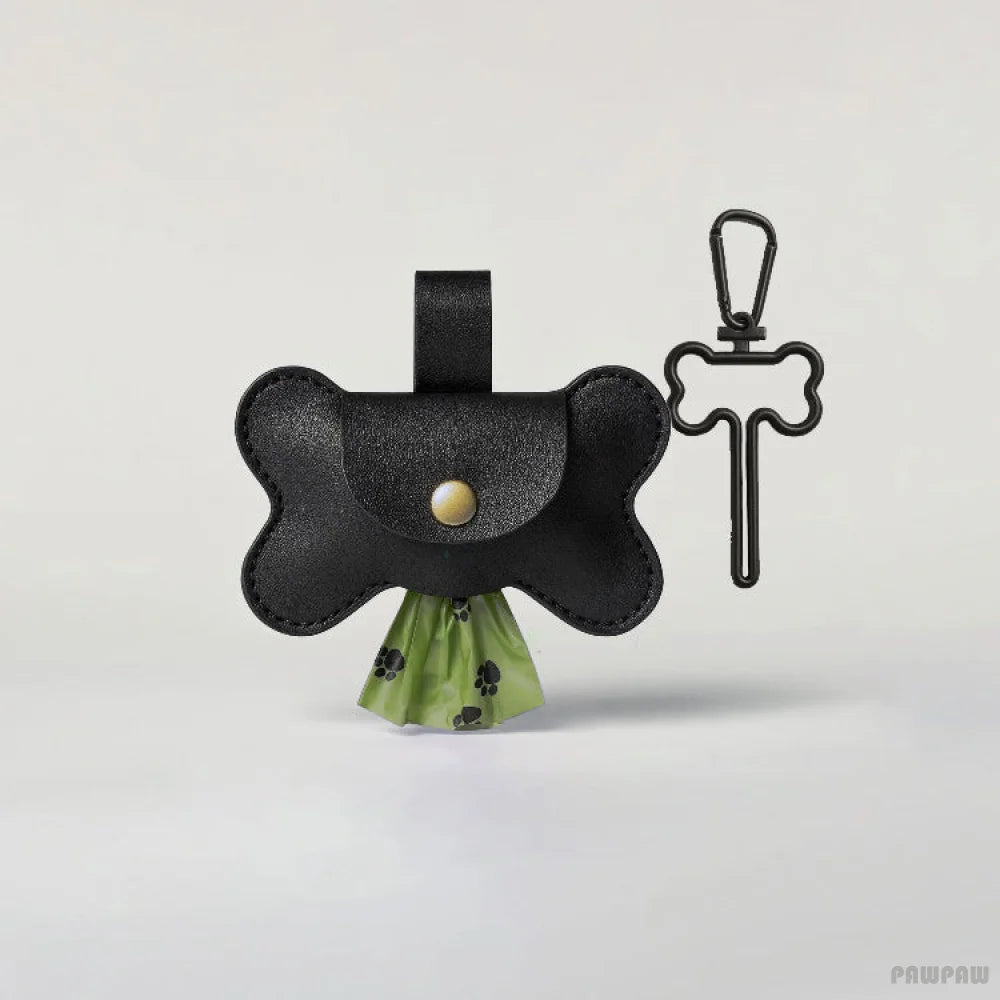 Black leather dog toy with green interior and bone-shaped keychain on a light gray background